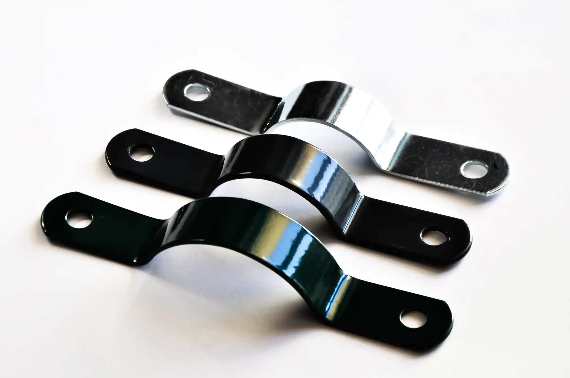 Obejma przelot do montażu siatki ogrodzeniowej w trzech różnych kolorach na białym tle